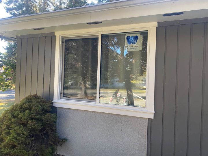 Finished window with custom white exterior trim on grey siding